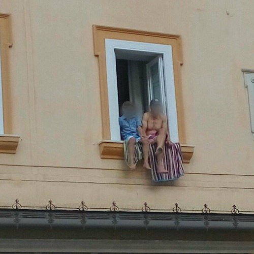 Amalfi, turista fai-da-te a torso nudo e in bermuda si sporge dalla finestra. Il ribrezzo sul web [FOTO]